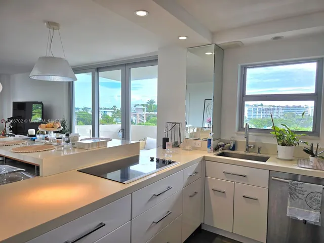 a kitchen with sink attached with living room