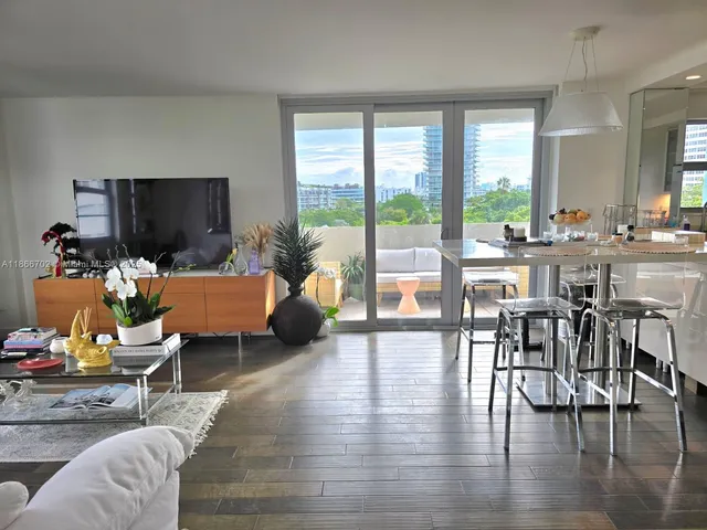 a living room with furniture and a flat screen tv with wooden floor