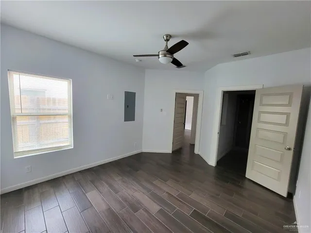 a view of empty room with wooden floor and window