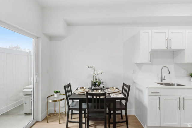 2085 North Main Street, Unit 306 Sunset, UT 84015 - Photo 9 of 18 Compact dining area featuring wood-finish flooring, white walls, and a sliding glass door leading to an outdoor space