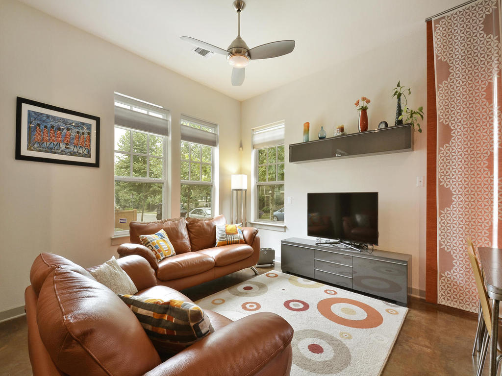 High ceilings and tall windows frame this inviting living space anchored by stained concrete flooring.
