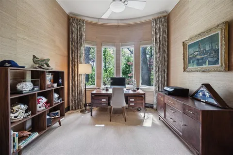 a view of a workspace with furniture and a window