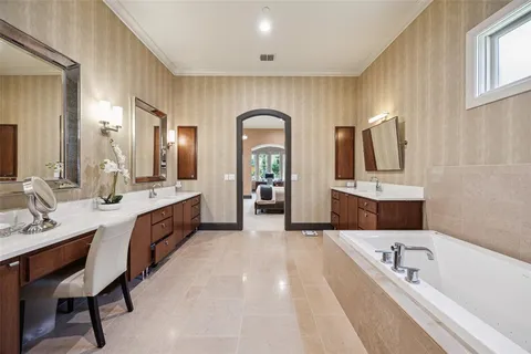 a spacious bathroom with a double vanity sink double mirror bathtub and window