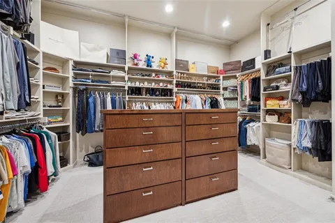 a view of walk in closet with clothes and shoes