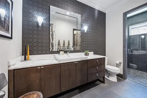 a bathroom with a double vanity sink toilet and mirror