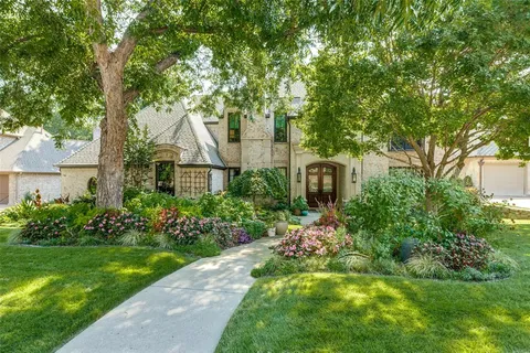 a front view of a house with a yard and shrubs