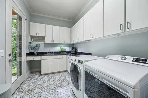 a utility room with stainless steel appliances granite countertop a washer and dryer
