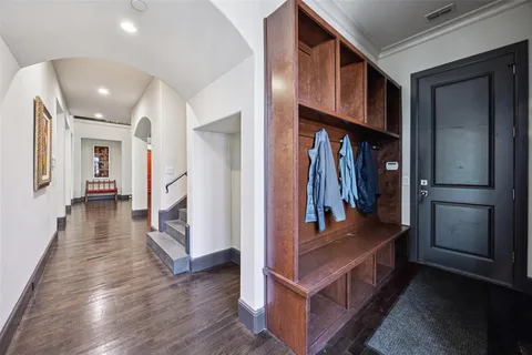 a hallway with wooden floor and stairs
