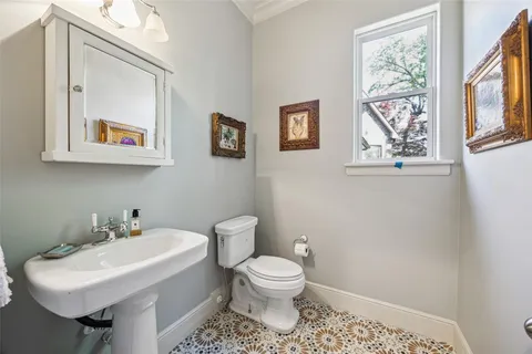 a bathroom with a toilet a sink and mirror
