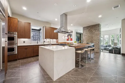 a kitchen with kitchen island granite countertop a sink counter top space appliances and cabinets