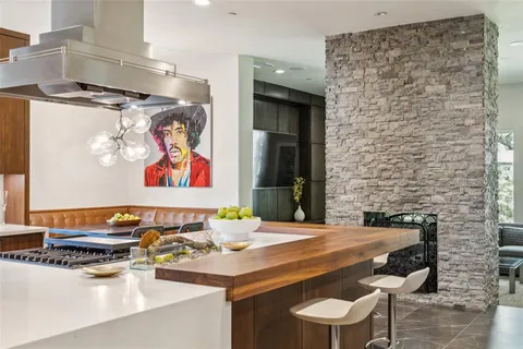 a room with stainless steel appliances kitchen island granite countertop a table and chairs