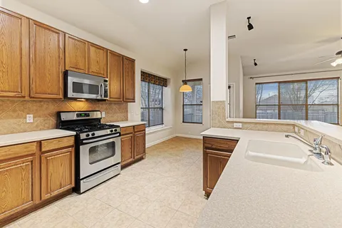 a large kitchen with a sink and dishwasher a stove top oven with a dishwasher