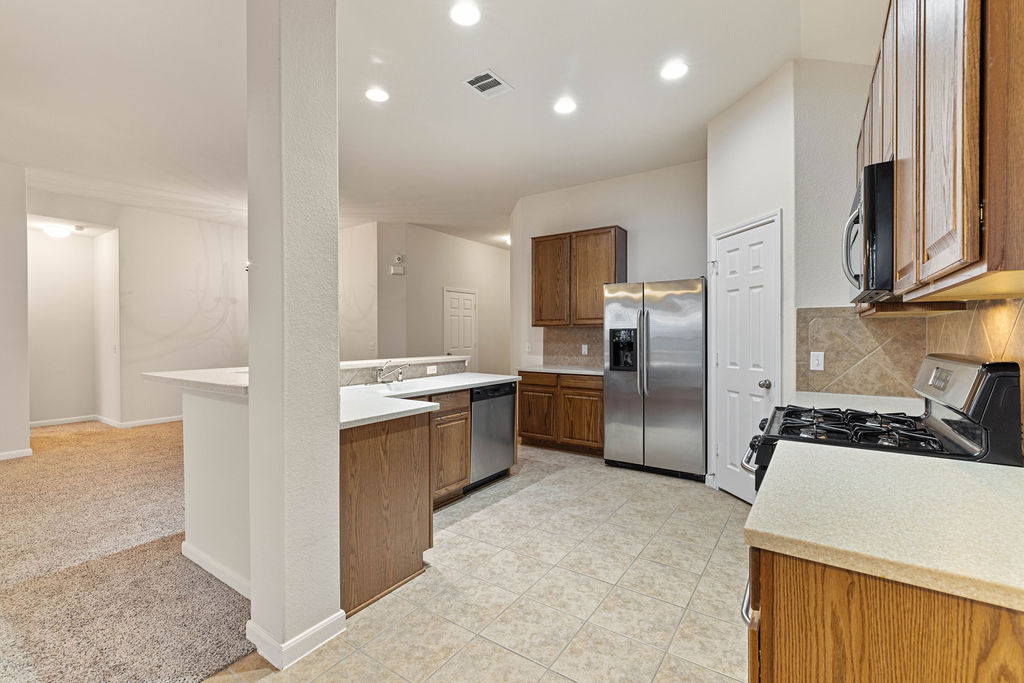 2134 Paradise Ridge Drive Round Rock, TX 78665 - Photo 10 of 28 a kitchen with refrigerator a microwave a sink and cabinets