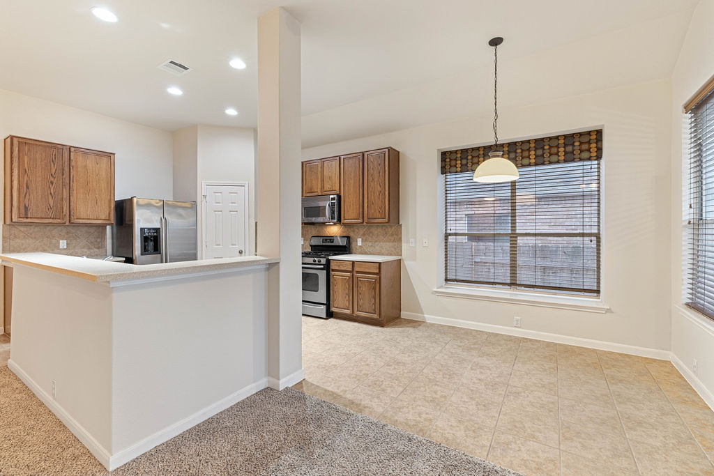 2134 Paradise Ridge Drive Round Rock, TX 78665 - Photo 11 of 28 a kitchen with stainless steel appliances granite countertop a stove a sink and a refrigerator