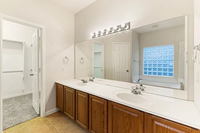 a view of an empty room with a window and cabinet area