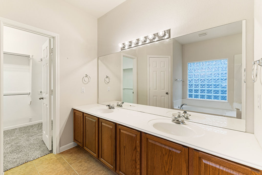 2134 Paradise Ridge Drive Round Rock, TX 78665 - Photo 15 of 28 a bathroom with a double vanity sink a mirror and a shower