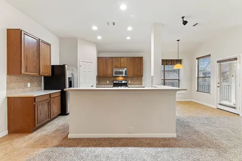 a view of a kitchen with a sink cabinets and stainless steel appliances