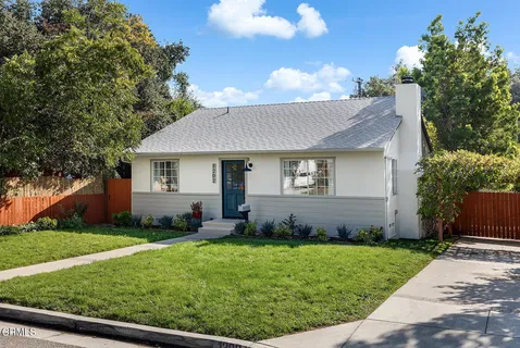 a view of a house with a yard and sitting area