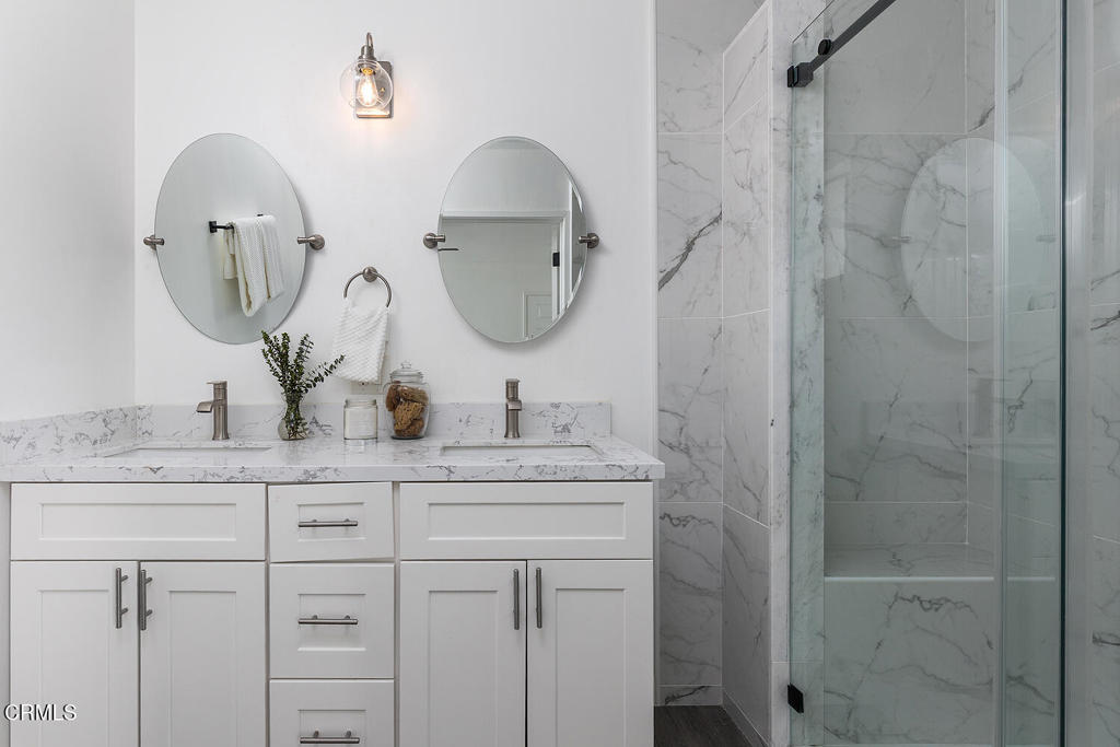 1202 East Lexington Street Pasadena, CA 91104 - Photo 15 of 39 a bathroom with a granite countertop sink a mirror and shower