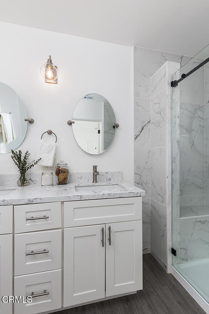 1202 East Lexington Street Pasadena, CA 91104 - Photo 16 of 39 a bathroom with a granite countertop sink a mirror a vanity and shower