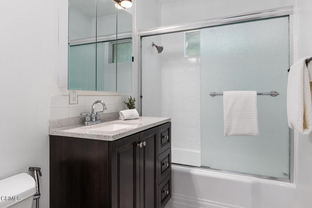 1202 East Lexington Street Pasadena, CA 91104 - Photo 19 of 39 a bathroom with a granite countertop sink and a mirror