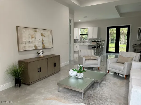 a living room with furniture and view of kitchen