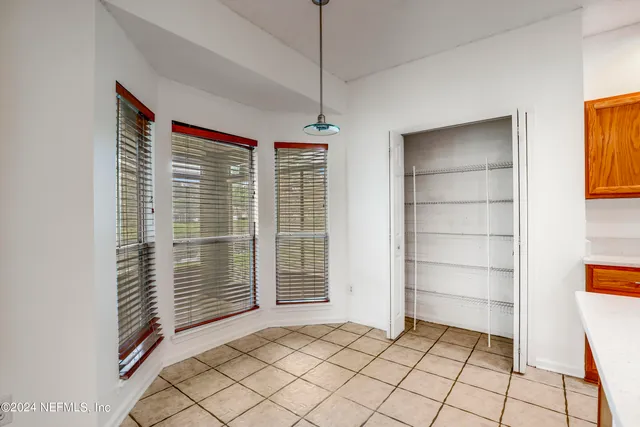 a view of an empty room with cabinet and window