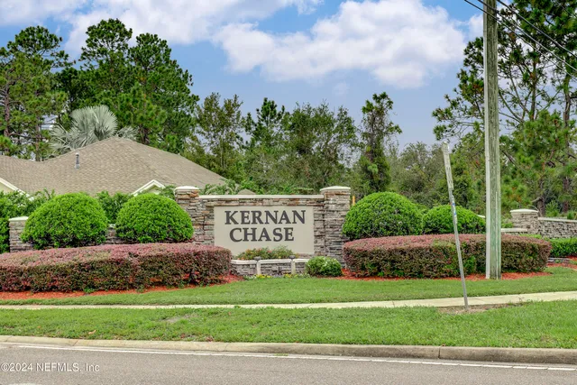 a front view of a house with a yard and green space