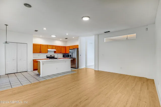 a large kitchen with stainless steel appliances kitchen island a large counter top and a stove top oven