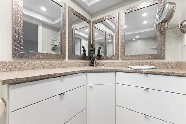 a bathroom with a granite countertop sink toilet a mirror and shower