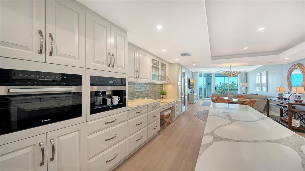 2410 Harbourside Drive, Unit 142 Longboat Key, FL 34228 - Photo 15 of 55 a large white kitchen with cabinets