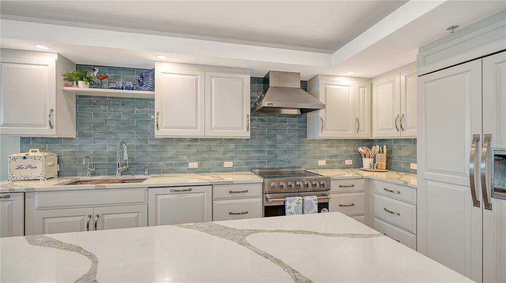 2410 Harbourside Drive, Unit 142 Longboat Key, FL 34228 - Photo 19 of 55 a kitchen with white cabinets stainless steel appliances and sink