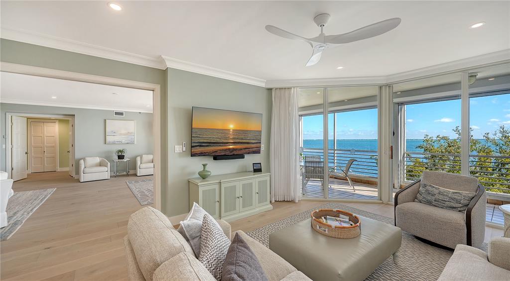 2410 Harbourside Drive, Unit 142 Longboat Key, FL 34228 - Photo 24 of 55 a living room with furniture a flat screen tv and a large window