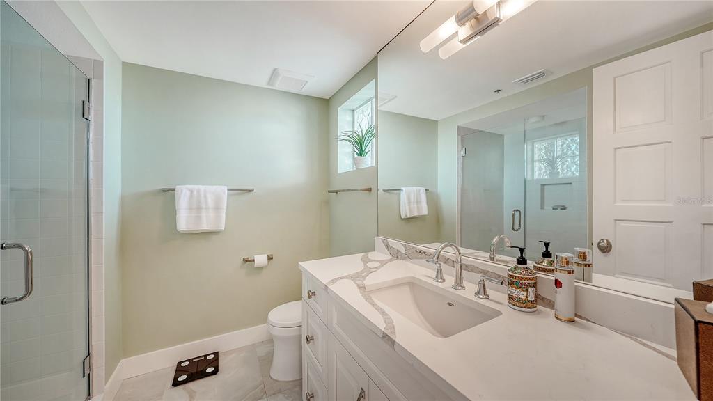 2410 Harbourside Drive, Unit 142 Longboat Key, FL 34228 - Photo 37 of 55 a bathroom with a sink a toilet and a mirror