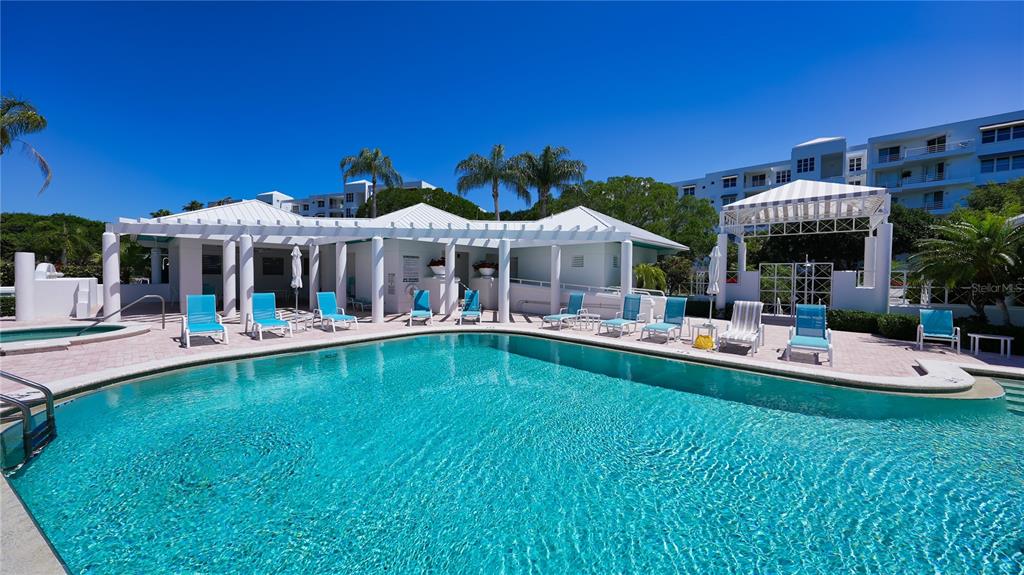 2410 Harbourside Drive, Unit 142 Longboat Key, FL 34228 - Photo 47 of 55 a view of a swimming pool with a table and chairs under an umbrella