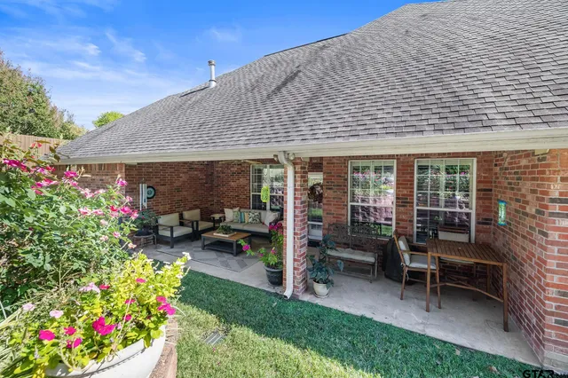 a patio with a table and chairs and potted plants