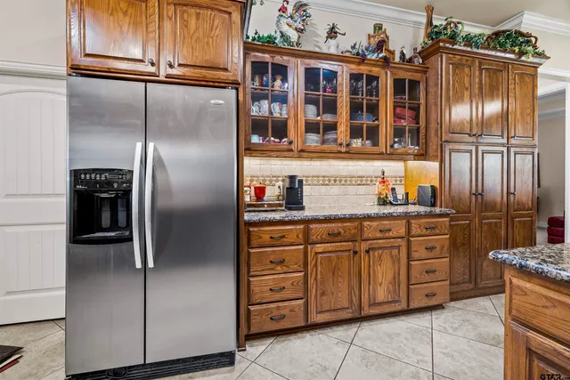 a kitchen with granite countertop stainless steel appliances a refrigerator and cabinets