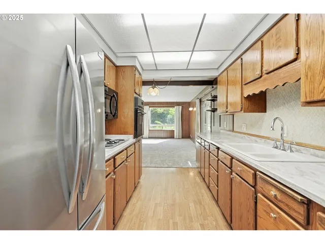 a kitchen with granite countertop a refrigerator and a sink