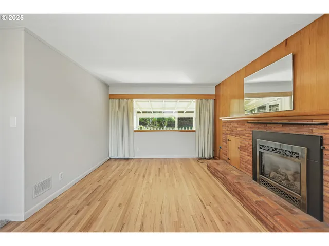 a view of an empty room with a fireplace and a window