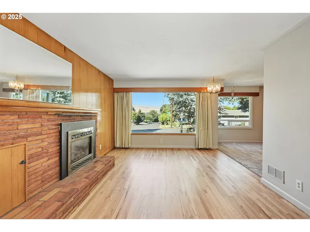a view of an empty room with a fireplace and a window