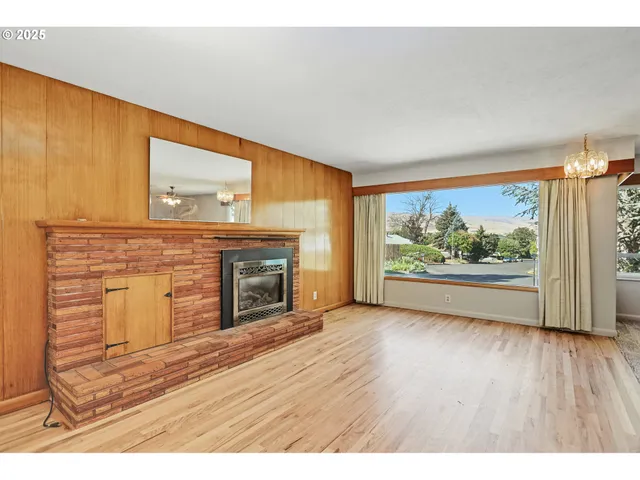 a view of an empty room with a fireplace and a window