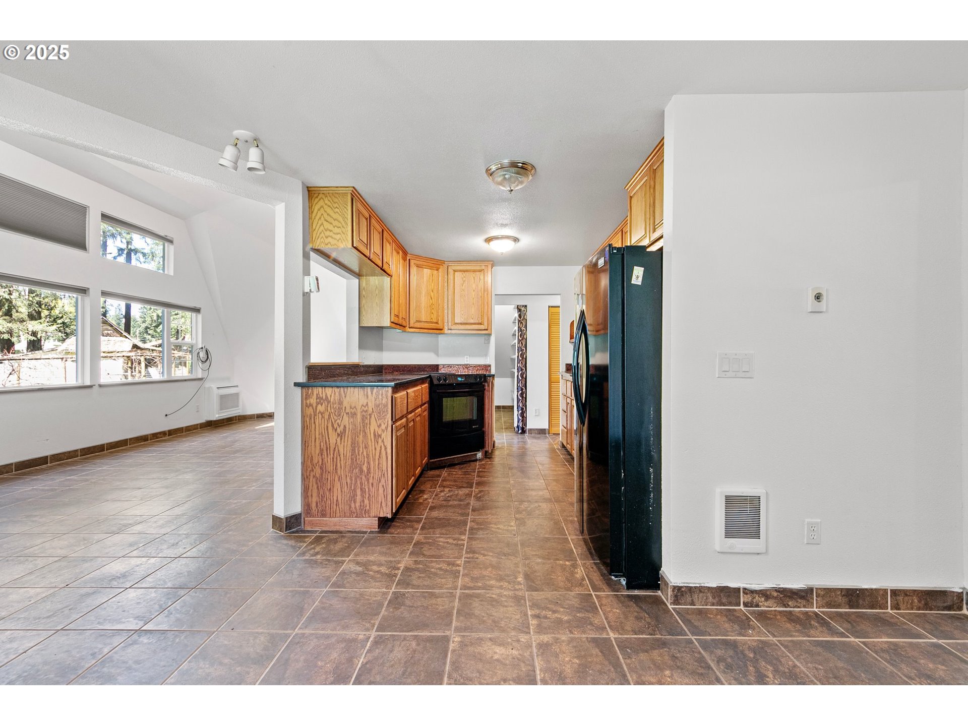 24458 Panther Creek Road Veneta, OR 97487 - Photo 16 of 46 a open kitchen with a stove a refrigerator and a fireplace
