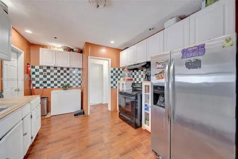 a kitchen with stainless steel appliances kitchen island granite countertop a refrigerator and a stove