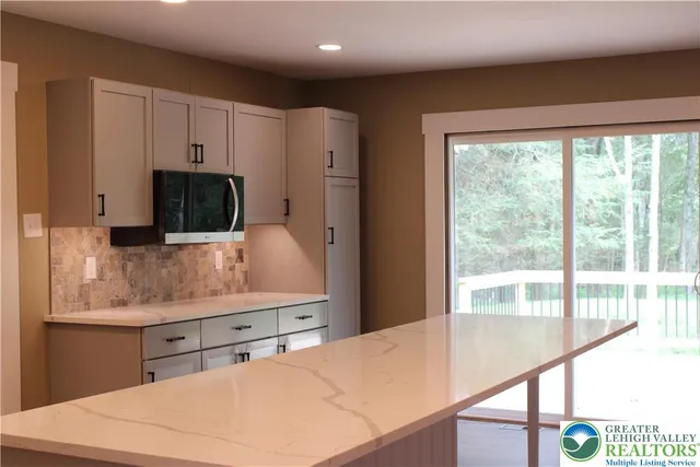 a kitchen with stainless steel appliances white cabinets and wooden floor