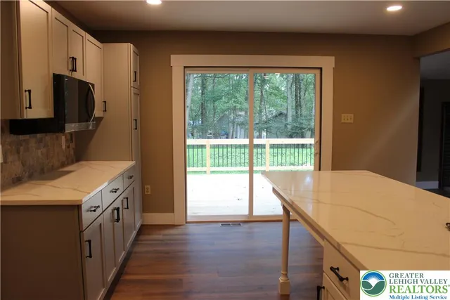 a kitchen that has a lot of cabinets and wooden floor