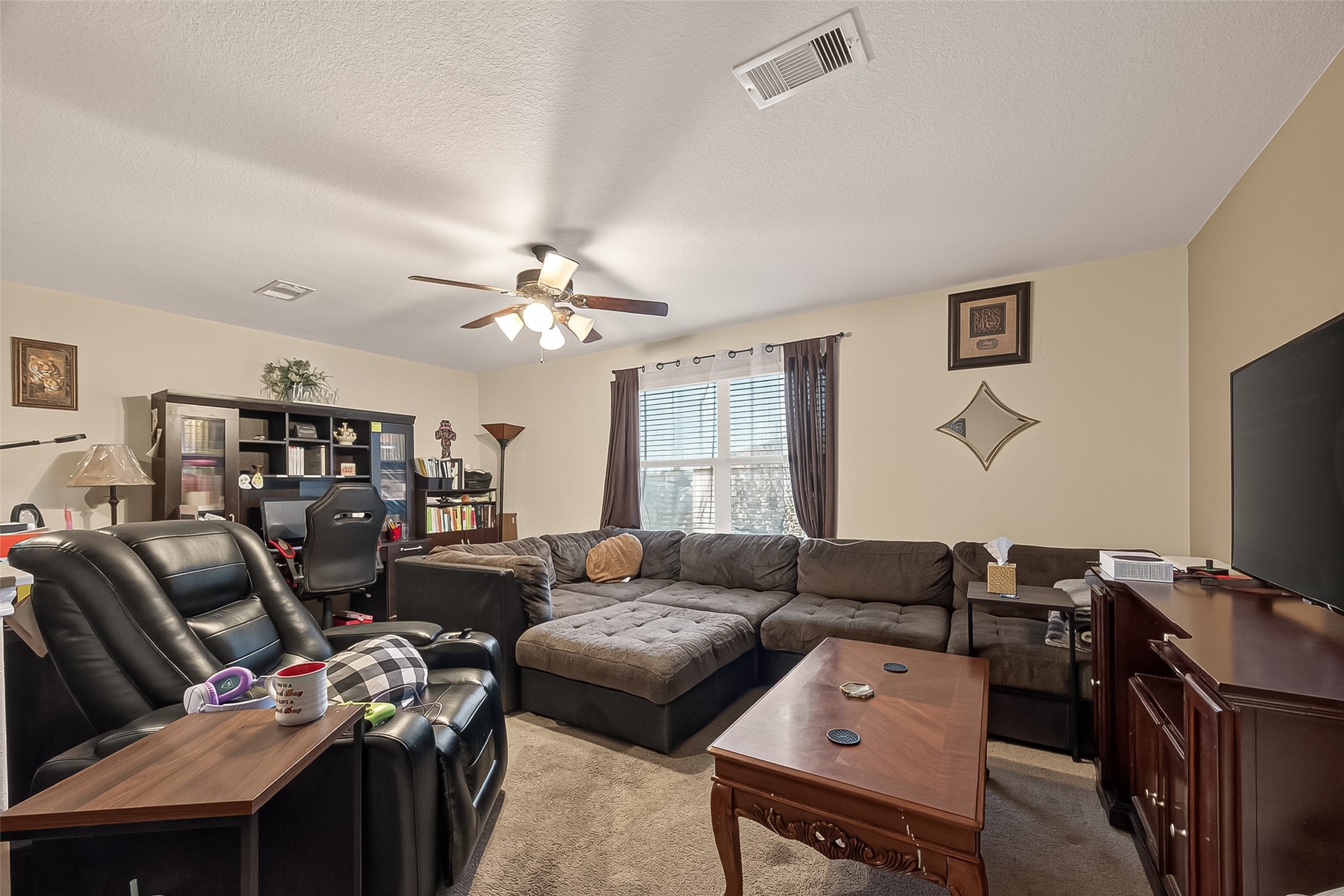 1019 Arnica Street Baytown, TX 77521 - Photo 13 of 16 a living room with furniture a bookshelf and a flat screen tv
