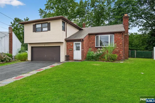 a front view of a house with a garden and yard