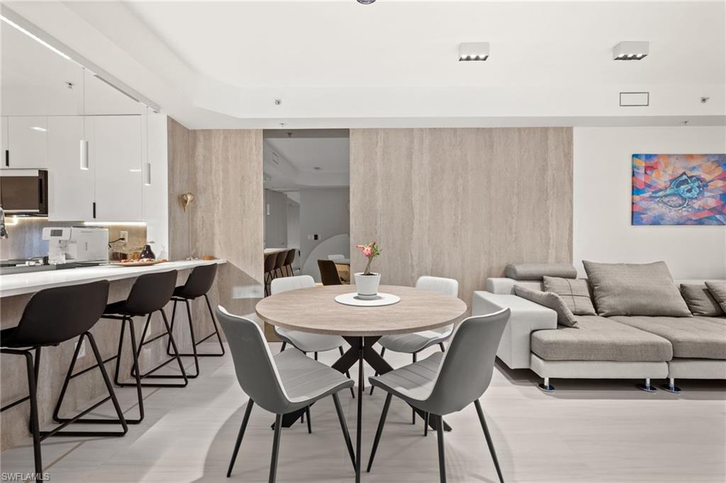 1100 Pine Ridge Road, Unit B103 Naples, FL 34108 - Photo 13 of 38 a view of a dining room with furniture and wooden floor