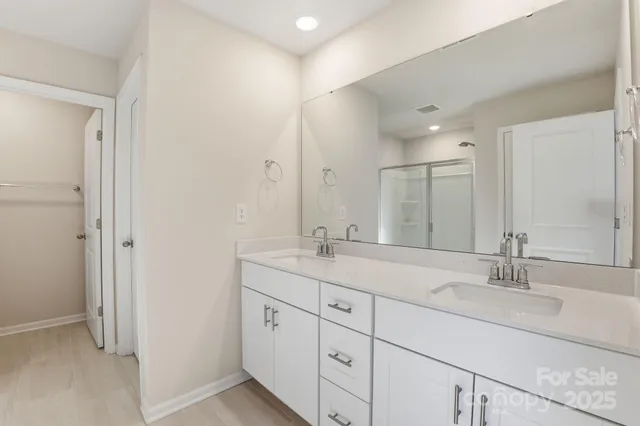 a bathroom with double sink and a mirror