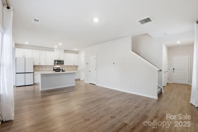 a view of kitchen with wooden floor and electronic appliances